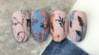 Hand painted motifs on nail-foiled background