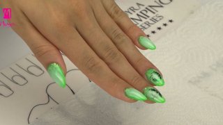 Vivid green, almond-shaped sculpted nails decorated with Holo glitter and milky ombre technique