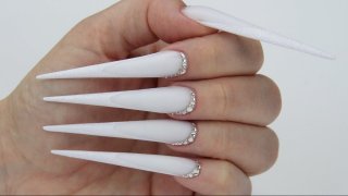 Stiletto-shaped nail in extreme length with French free edge effected with Diamond shine powder