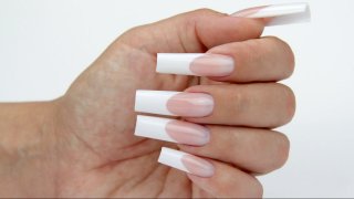 Square-shaped nail in extreme length with filed smile line, nail bed extension and white free edge