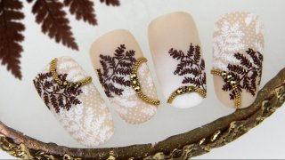 Nail art with stones, beads and fern leaf motives